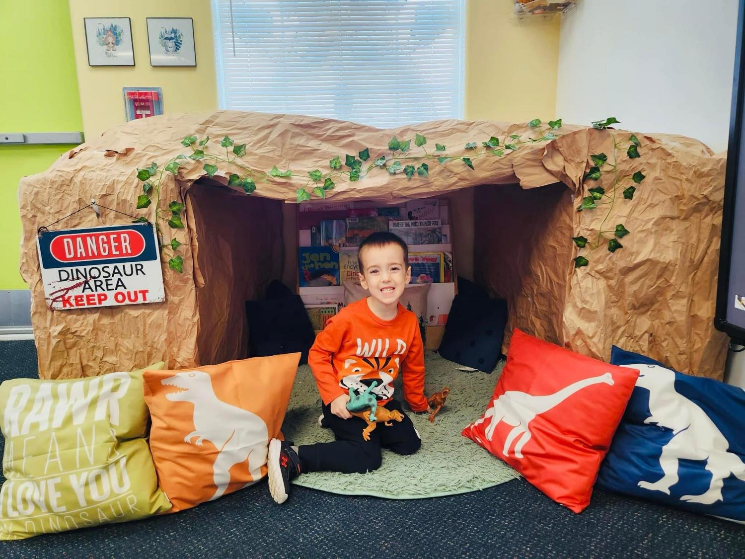 Child in dinosaur cave classroom